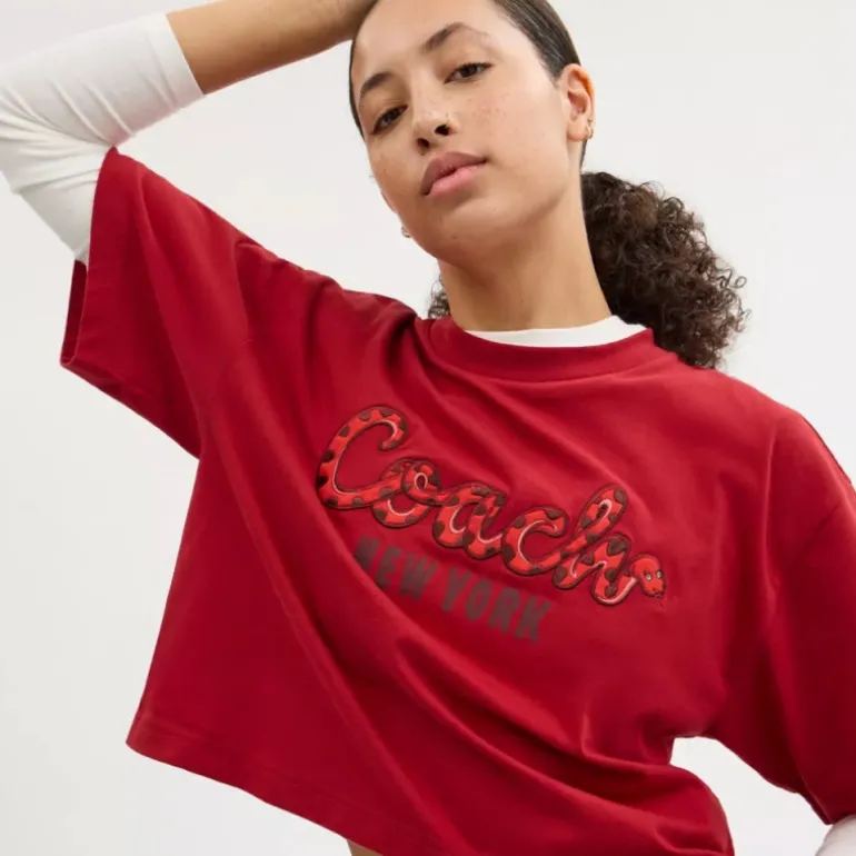 New Year Cropped-T-Shirt aus Biobaumwolle mit Schriftzug in Schlangenoptik*COACH Hot